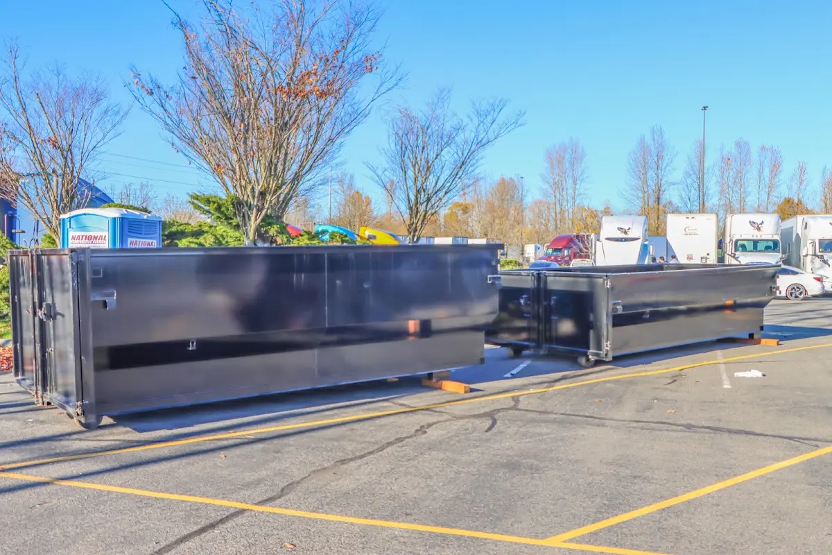 Professional dumpster rental service with roll-off container on residential driveway in Massena